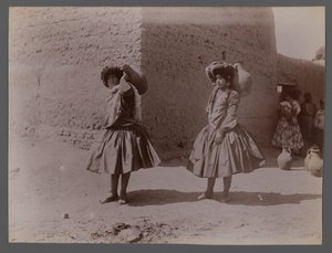 Two women carrying clay jugs