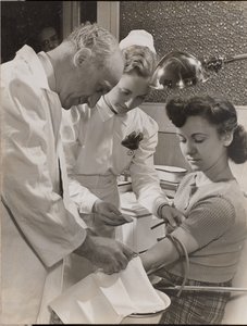 Doctor and nurse inserting a needle into a woman