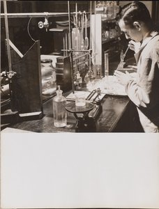 Man in a Lab Using a Large Pipette by Arnold Eagle