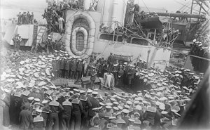 Seamen crowd around Australian Prime Minister William Morris (Billy) Hughes as he addresses them on the deck of HMAS Australia at the dockyard in Devon, England, 21 May 1916 by Australian Photographer