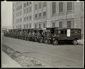 A line of delivery trucks parked outside the Carolyn Laundry at 111 East 128th Street, East Harlem, New York, 1929 by Byron Company