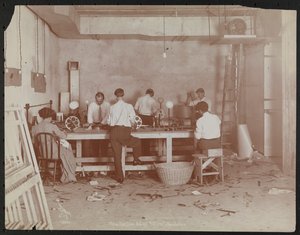 Film laboratories at Carlton Motion Picture Co. with five men and one woman working with film, splicing etc., New York