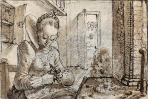 A fashionable young woman sits at a kitchen table to shell walnuts