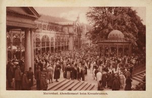 Postcard depicting a crowd of people attending an evening concert at Kreuzbrunnen