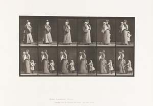 Walking carrying child, turning around; another child holding on to dress