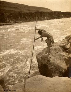 Tlakluit Indian, standing on rock, fishing with dip net by Edward Sheriff Curtis