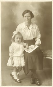 Pretty girl, mother or governess, showing photos to young child