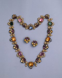 A fine Regency gold and jewelled necklace set with cushion-cut topaz, amethysts, pink tourmalines, emeralds, sapphires and peridots, with a pair of flowerhead earrings, c.1810 by English School