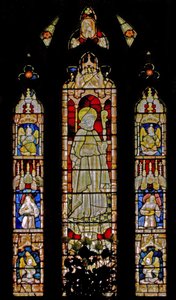 The East window depicting musician angels surrounding the central figure of a sainted bishop