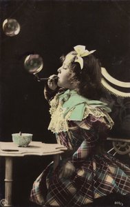 A little girl blowing bubbles from a pipe by French Photographer