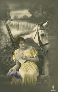 Girl sitting on sofa with white horse behind by French Photographer