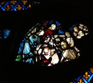 The west rose window depicting a scene from the Book of Revelation: Souls being arrayed in white robes by angels