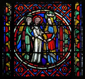 Window s1-C an angel pushes the re-clothed St Bonnet to the Virgin. She gives him a red chasuble with which to celebrate Mass for her by French School