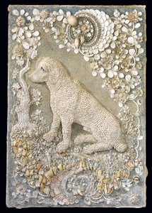 One of a pair of Louis XV seated dogs modelled in relief, within a grotto-like surround