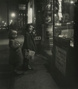 Two Little Girls in Winter Coats Standing Outside a Shop at Night