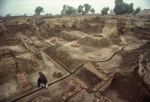 Overview of a pit filled with the remains of brick walls and a brick well by James L Stanfield