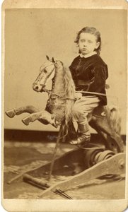 Young boy with whip on rocking horse