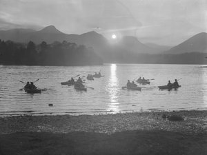 A view of people canoeing on Derwentwater at either sunrise or sunset by Joseph Hardman