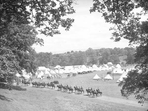 Mounted cavalry moving along road towards their camp with tents in the background by Joseph Hardman