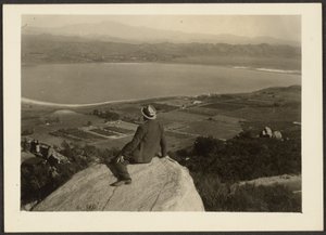 Man on Rock Promontory Overlooking Farmland by Louis Fleckenstein