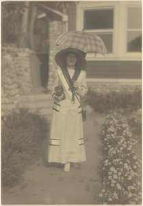 Woman Standing in Front Yard with Camera and Plaid Umbrella by Louis Fleckenstein