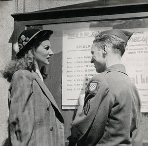 Soldier with a young woman in front of a Viennese theater poster by Luigi Leoni