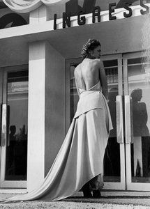 Model seen from the back wearing an evening dress created by the couture house "Graldi"