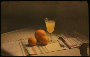 Still life photograph of fresh oranges and a glass of orange juice