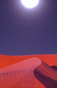 Flares over desert sand dunes glow at midnight near Lekhwair oil and natural gas fields by Lynn Abercrombie