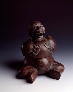 Pre-Columbian Art, Mayan Civilization, Initial Period: Anthropomorphic Clay Vase Depicting a Man Sitting with His Hands on His Chest Wearing a Monkey Mask with His Mouth Open. From Uaxactun, Guatemala. Guatemala, Museo Nazionale di Archeologia