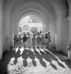 European children in school uniform under arch with shadows