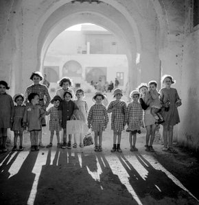 European children in school uniform under arch with shadows