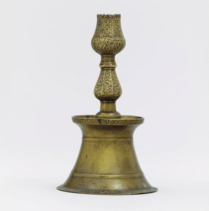 An Ottoman brass candlestick, the neck with incised arabesque decoration rising into the shape of a tulip