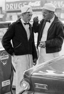 Instructor speaking with a young man training to be gas station attendant at Chevron station