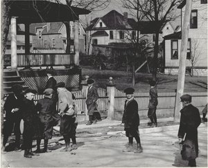 A Group of Boys in Winter Coats Standing on an Unidentified Street Either Before or After a School Day. by Unbekannt