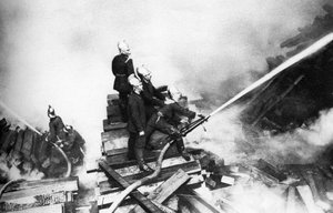Firemen fighting a fire at a timber yard, London