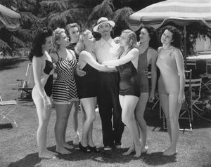 Hollywood, California: c.1935 Seven young women in bathing suits vie for the attentions of a single man