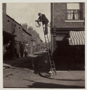 Man cleaning a gas street light, c 1905 by Unbekannt