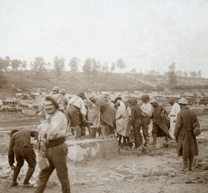 Soldiers queuing in the mud for water, Genicourt, northern France