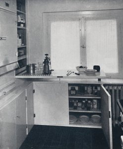 Kitchen with a black Dutch tiled floor, white walls and built-in shelves and cupboards by Unbekannt