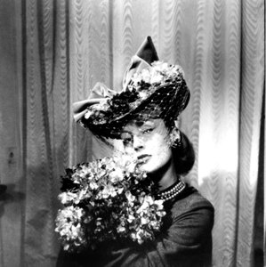 Woman wearing a hat with a veil, holding a bouquet of flowers, Paris by Unbekannt