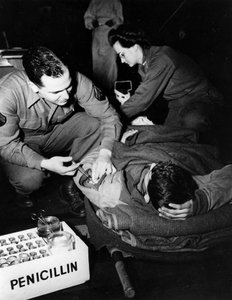 Second World War: Luxembourg February 1945: In a US Army evacuation hospital, a medic (nurse) administers penicillin to an injured soldier to avoid infection while a nurse prepares him for an operation by Unbekannt