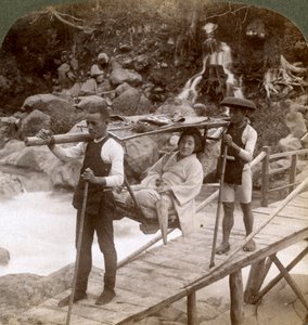 Japanese woman in a yamakago mountain chair crossing the torrential Daiya river near Nikko, Japan