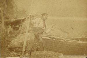 Man Posing Beside Rowboat by Unknown artist/maker