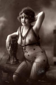 A young woman sitting down, wearing a transparent dress by Unknown photographer