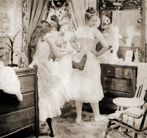Reducing the Surplus, stereoscopic card depicting a young woman being laced into a corset, c.1900