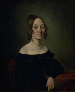 Portrait of a Girl in a Black Dress Sitting at a Table