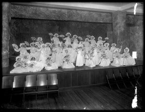 Group of little girls posed on a small stage holding fans, probably the Roman Catholic Orphan Asylum, Kingsbridge, Bronx, c.1911 by William Davis Hassler