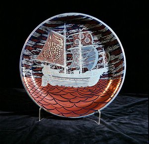 Charger with silver lustre, with a galleon sailing on a red lustre sea by William de Morgan