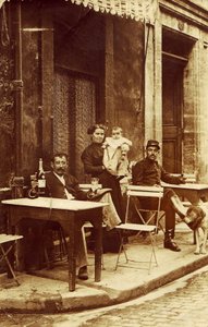 Man holding a bottle of absinthe, c 1900, on a cafe terrace